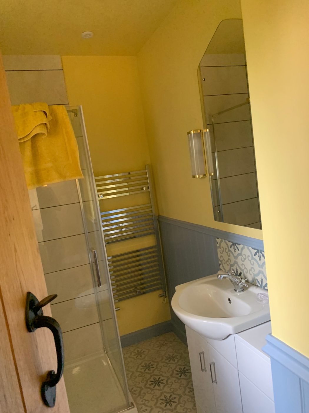 Sunny shower room: Cheerful yellow walls over soft grey panelling and skirting.