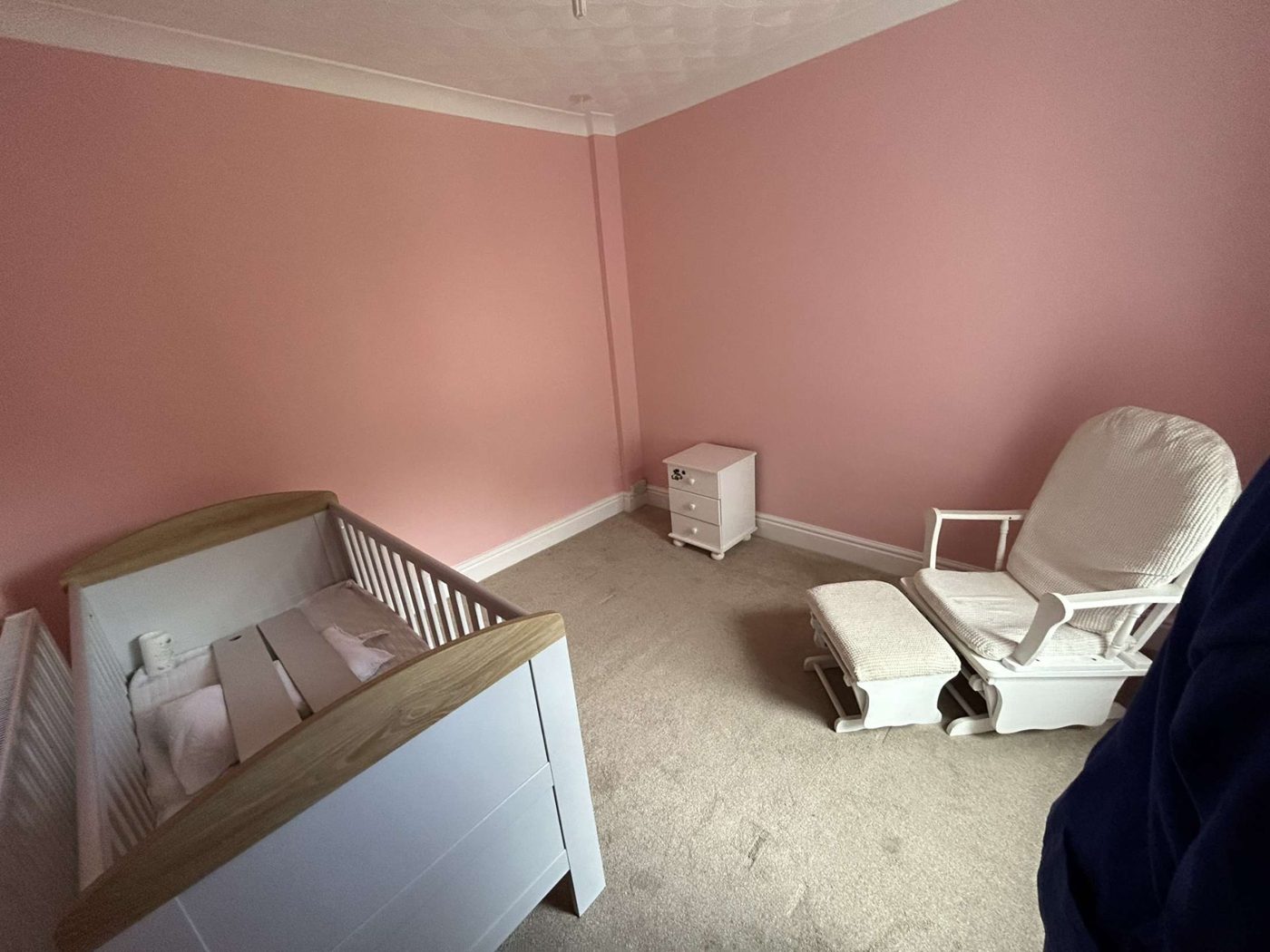 Soft pink nursery: Warm blush walls with clean white skirting and ceiling for a calm, restful room.